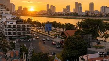 Un paisaje urbano con un río, edificios y un atardecer.