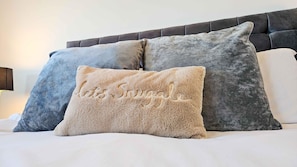 Ein Bett mit drei Kissen und einem Kopfteil.