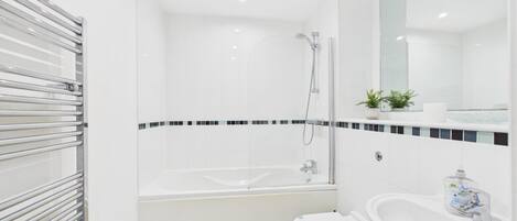 A modern bathroom with a bathtub, a toilet, a sink, and a shower.