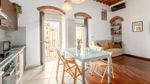 Una cocina moderna con comedor, piso de madera y balcón con vistas.