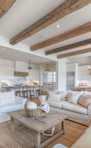 A spacious living area with a sofa, coffee table, and a kitchen in the background. - Lakefront on Chesapeake in North Dewey (Dewey Beach)