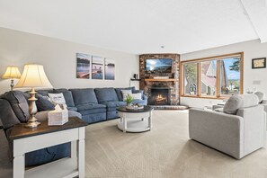 Ein Wohnzimmer mit Kamin, einer Couch, einem Couchtisch und einer Lampe.