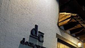 A building entrance with a sign reading 'DC DOCE CUARTOS' and a wooden door. - Docecuartos Hotel (San Cristóbal de las Casas)