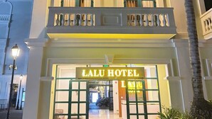 Un hotel con una entrada destacada, balcones y un cartel que dice 'Lalu Hotel'.