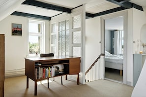 A bedroom with a bed, a desk with books, a window, and a staircase. - Soul in a 100-year-old villa on Langeland (Tranekær)