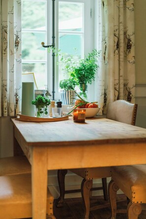 A dining table with a candle, a bowl of fruit, and a potted plant. - Forester's house with sauna near Eggegebirge (Lichtenau)