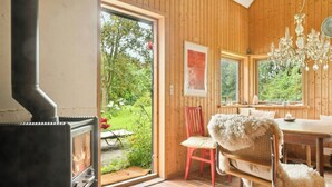 Un intérieur en bois avec une cheminée, une table à manger et une chaise.