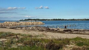 A coastal landscape with a rocky breakwater, calm water, and distant land. - Comfortable summer house in Aabenraa (Aabenraa)