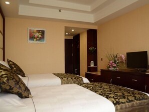 A hotel room with two beds, a television, a desk, and a painting on the wall. - Green Oriental Hotel ) (Weifang)