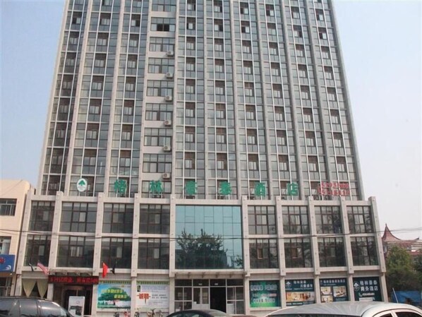 A multi-story building with a modern architectural design, featuring a large glass facade and multiple balconies. - Green Oriental Hotel ) (Weifang)