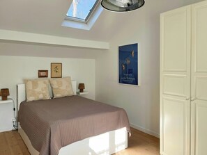 A bedroom with a bed, a skylight, a wall-mounted poster, and a wardrobe. - House in peaceful surroundings 150 m to the water (Asperup)