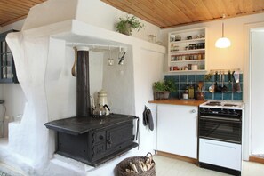 Eine Küche mit einem schwarzen Herd, weißen Schränken und einem weißen Kühlschrank.