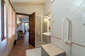 A hallway with a wooden door, a white sink, and a white toilet. - Tuscan villa with pool in the heart of Tuscany (Bucine)