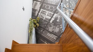 Een trap met een houten leuning en een poster voor een winkel.