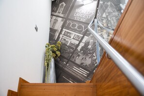 Eine Treppe mit einem Holzgeländer und einem Plakat, das ein Geschäft bewirbt.