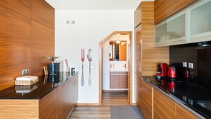 Een moderne keuken met houten keukenkastjes, een zwart aanrecht en een inbouwoven.