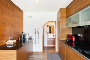 Eine moderne Küche mit Holzschränken, einer schwarzen Arbeitsplatte und einem eingebauten Backofen.