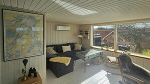 A cozy room with a map, a sofa, a table, and a rocking chair. - Cozy cottage with fjord view in Hjarbæk (Løgstrup)