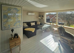 A cozy room with a map, a sofa, a table, and a rocking chair. - Cozy cottage with fjord view in Hjarbæk (Løgstrup)