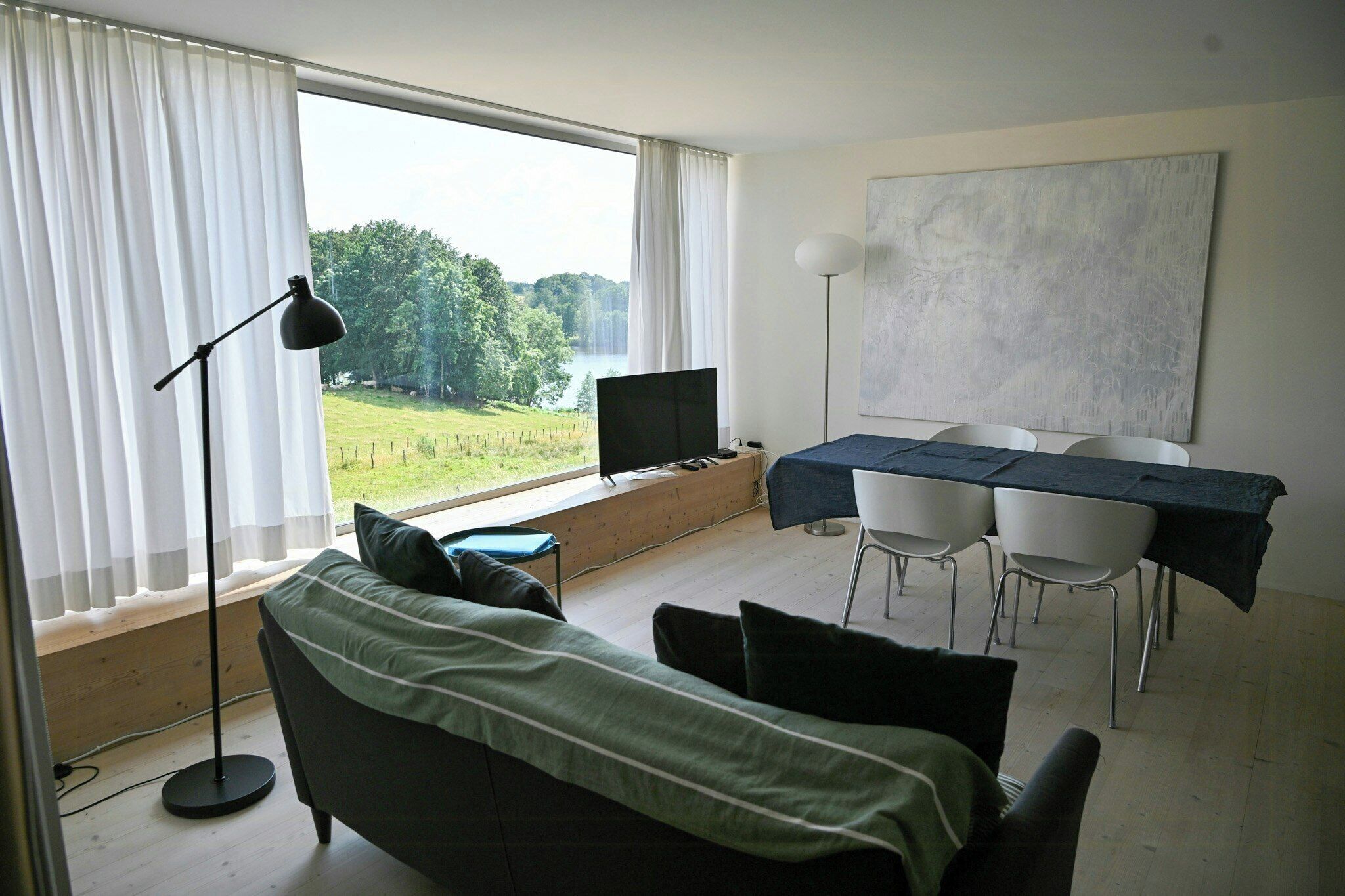 Una habitación moderna con cama, escritorio y vista al lago.