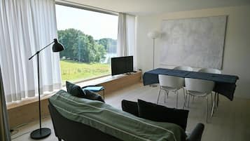 Una habitación moderna con cama, escritorio y vista al lago.
