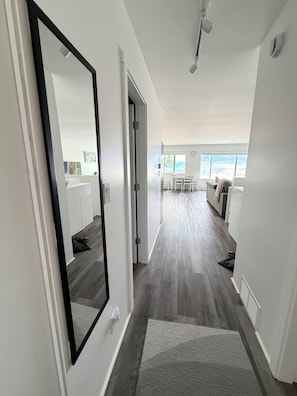 Interior moderno com um corredor que leva a uma sala de jantar e vista para o exterior.