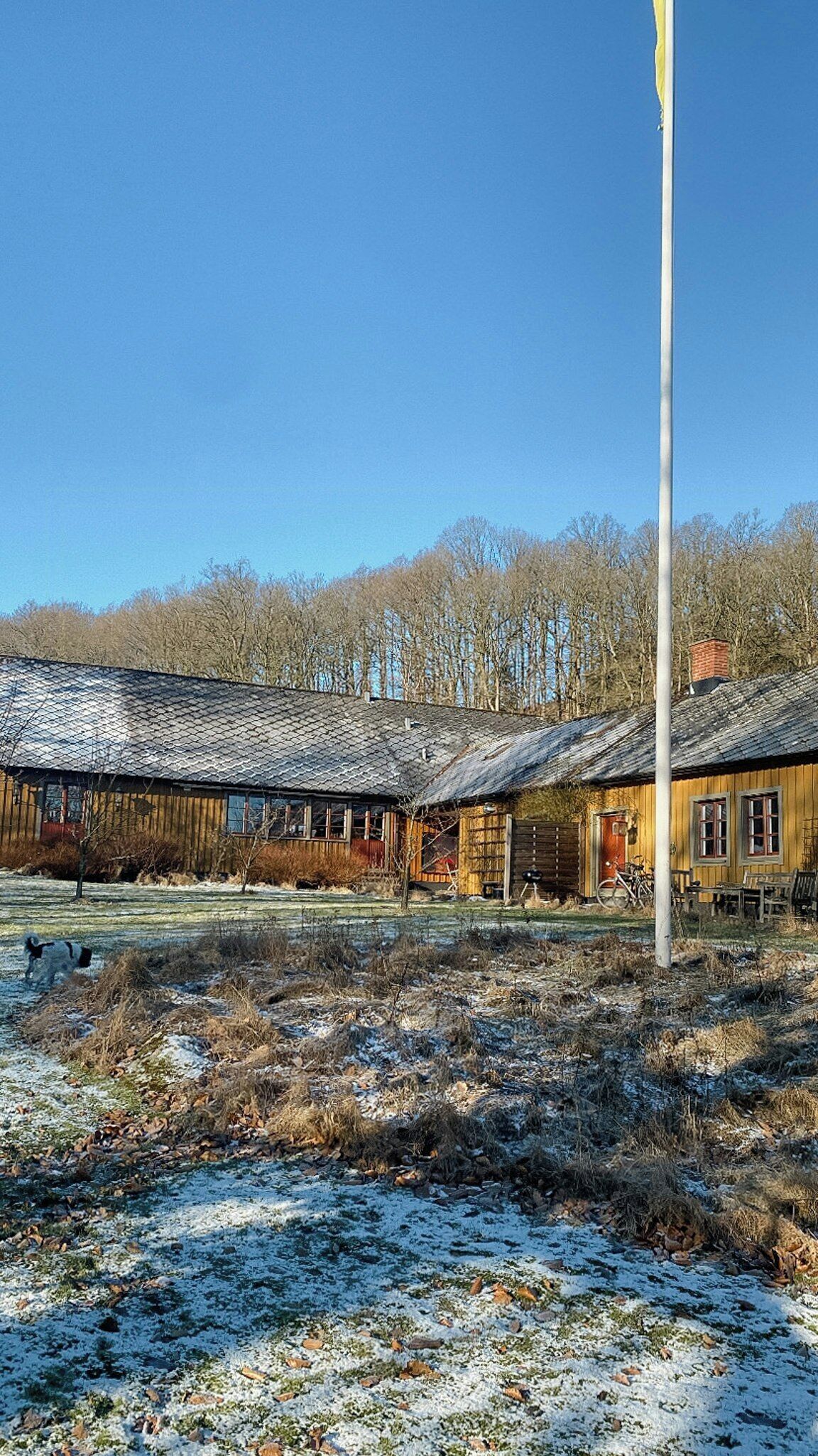 Une rangée de bâtiments en bois, avec un poteau métallique au premier plan.