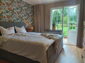 A bedroom with a bed, a window, and a view of the outdoors.
