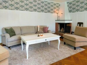 A living room with a sofa, a coffee table, and a fireplace.