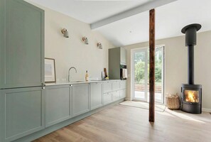 Eine moderne Küche mit Einbauherd, einem großen Fenster und einem minimalistischen Design.
