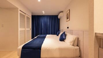 A bedroom with a bed, a wardrobe, a ceiling light, and a wall-mounted air conditioner.
