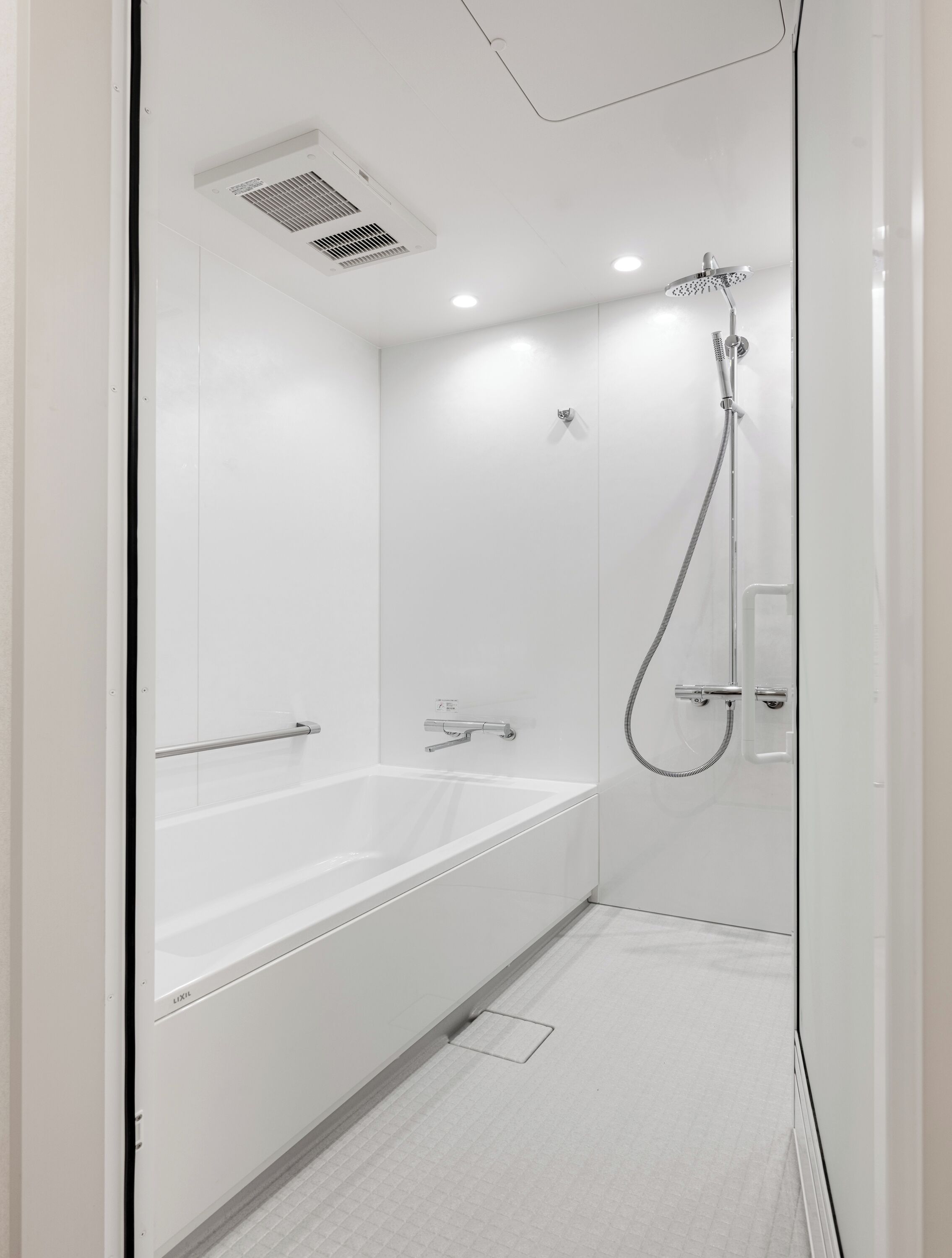 Un baño moderno con bañera, ducha y sistema de ventilación.