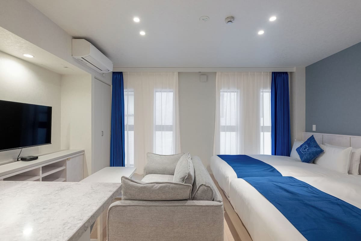 A hotel room with a bed, a TV, a desk, and a chair.