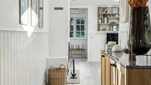 Une cuisine moderne avec des meubles en bois, un îlot central et une vue sur la salle à manger.