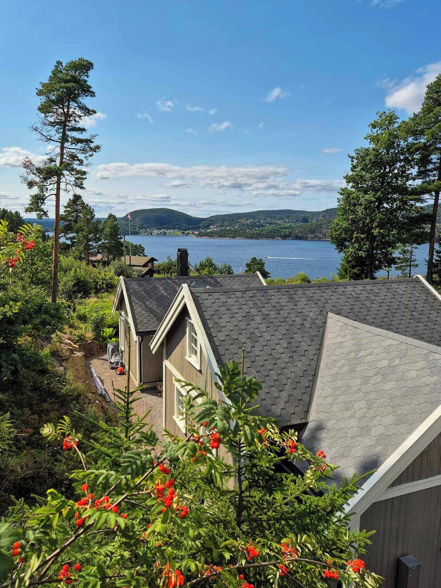 A residential area with a house, a small shed, and a view of a lake.