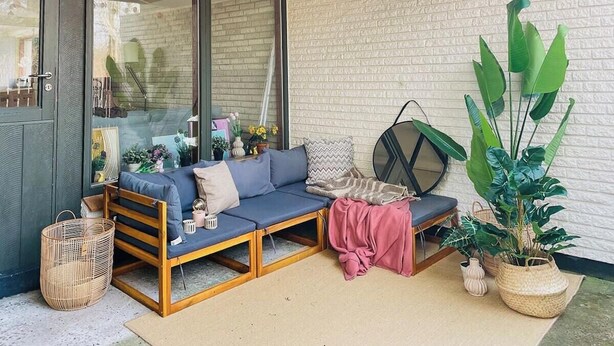 A cozy outdoor seating area with a sofa, cushions, and potted plants. - Colorful character and charm by Nakskov Fjord (Nakskov)