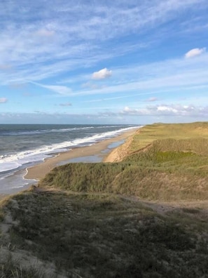 A coastal landscape with a beach, grassy dunes, and a clear sky. - Holiday home with sea views over the Western Sea (Vestervig)