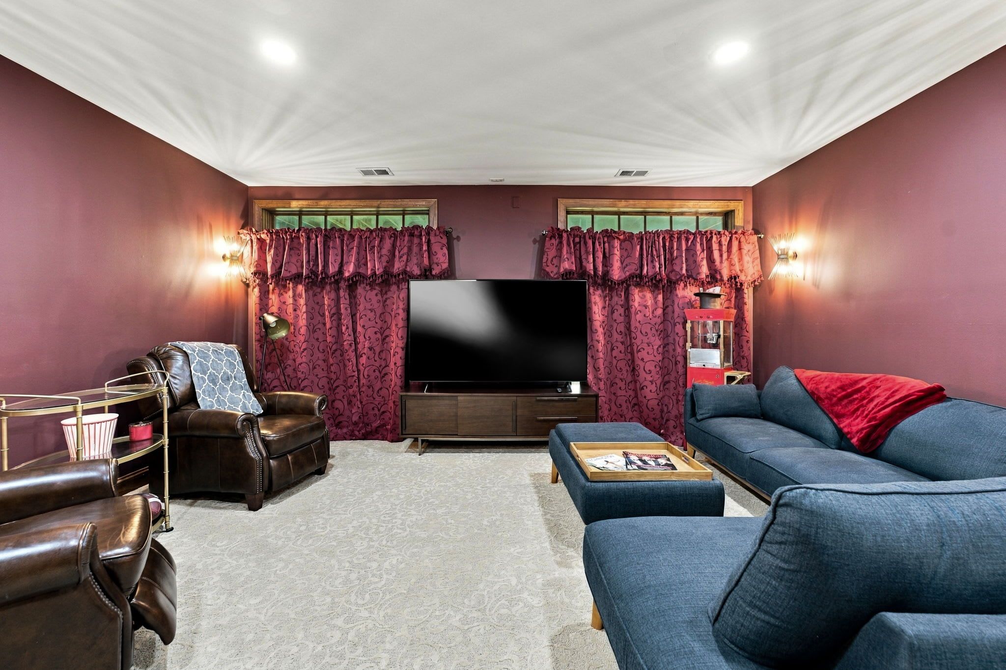 A living room with a flat-screen TV, leather armchairs, a sofa, and a coffee table.
