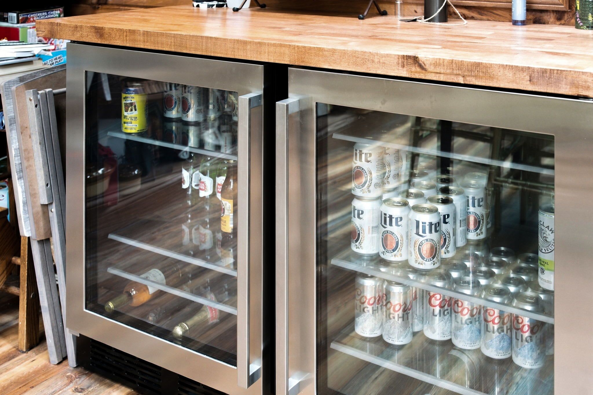 Een koelkast met planken vol bierblikjes.