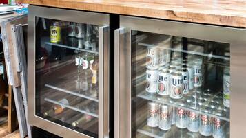 Een koelkast met planken vol bierblikjes.
