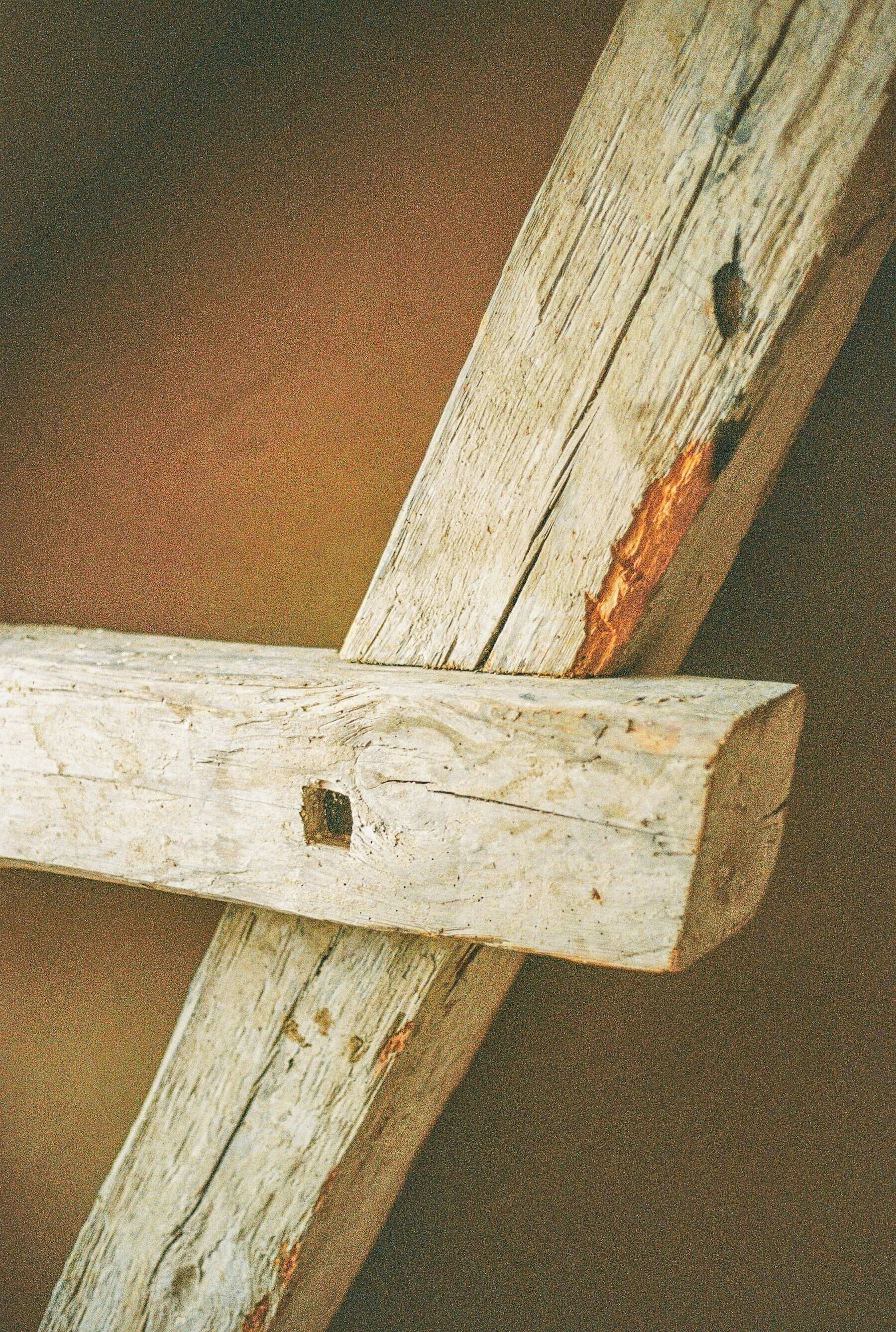 Ein Detailaufnahme eines verwitterten Holzbalkens.