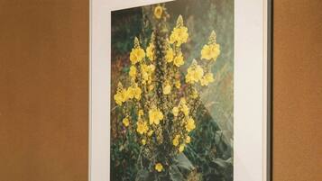Ein gerahmtes Bild von gelben Blumen an einer braunen Wand.