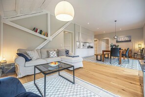 Ein modernes Wohnzimmer mit Sofa, Couchtisch und Essbereich.
