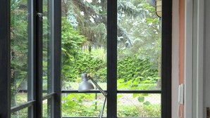 A room with a table and chair, large windows, and a view of greenery outside. - Inspiring holiday home on the Havel (Werder (Havel))