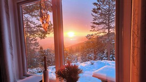 A room with a large window, a desk, and a vase with flowers. - Cozy private holiday home on Lifjell (Bø)