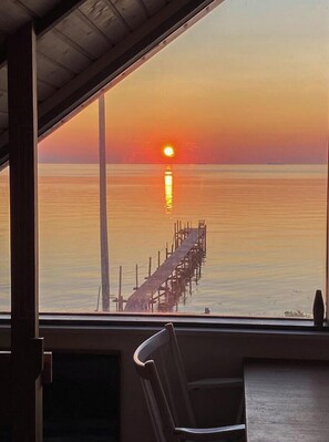 A sunset view from a window overlooking a pier extending into calm waters. - Home with views and walking distance to nature (Nyborg)