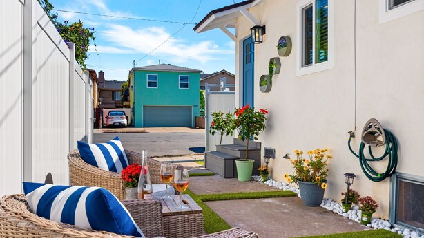 A residential property with a patio, wicker furniture, potted plants, and a garage. - Stylish North Park Escape - Private Patio (San Diego)