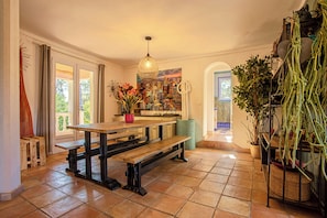 A dining area with a wooden bench, a hanging light fixture, and a potted plant. - Authentic villa in the Var countryside (Les Arcs)