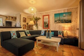 A living room with a sectional sofa, a coffee table, a fireplace, a painting, and a lamp. - Authentic villa in the Var countryside (Les Arcs)