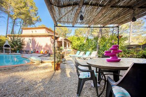 A poolside area with a pergola, lounge chairs, and a table with a decorative item. - Authentic villa in the Var countryside (Les Arcs)